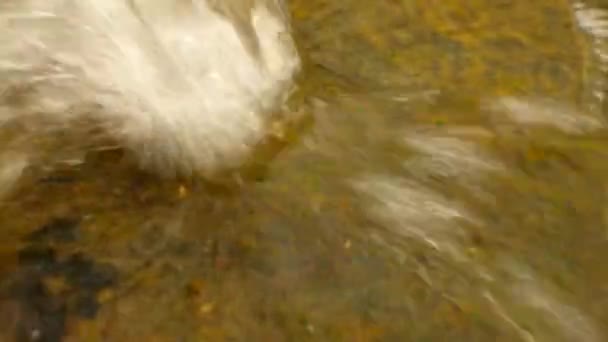 Spruzzare acqua dal tubo di scarico di plastica sta correndo verso il basso per masso e bolle creano sul livello dell'acqua schiumosa . — Video Stock