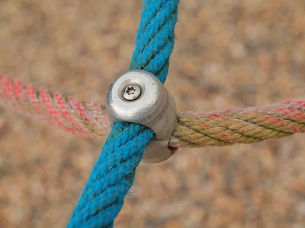 Point de joint de fer de cordes dans la toile d'araignée des enfants avec vis. Détail des cordes bleues croisées dans l'équipement extérieur d'escalade de sécurité . — Photo