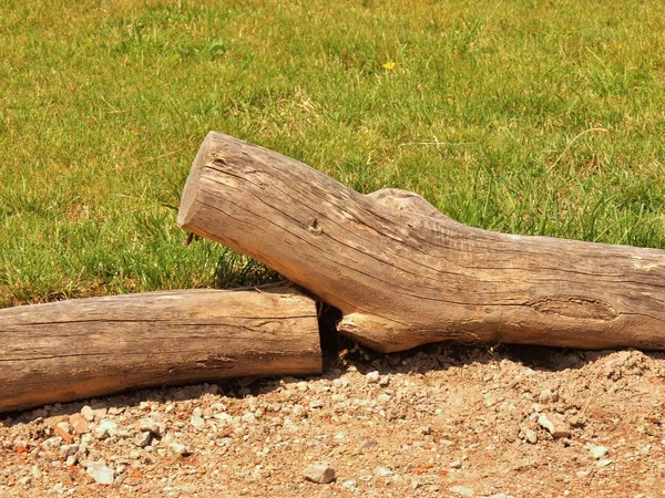 Empalizada horizontal de madera natural hecha de troncos naturales, cerca de madera entre el sendero y la hierba —  Fotos de Stock