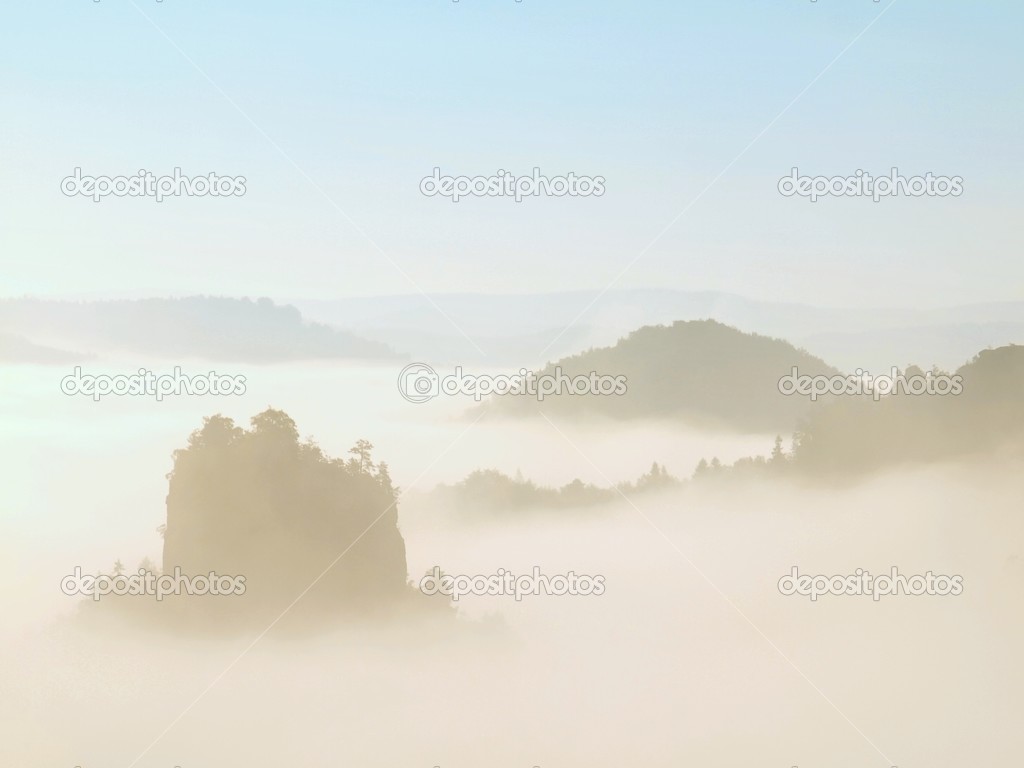 Magnificent fogy landscape, gentle blue pink misty sunrise in a beautiful valley of Saxony Switzerland park. Hills increased from fog.