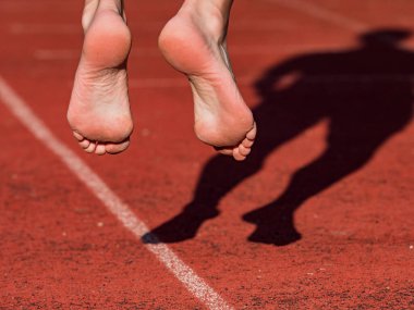 Stadyum ovalindeki antrenmandan önce ısınmak ve ısınmak. Orta yaşlı bir kadının vücudu.