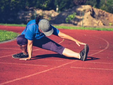 Esneme egzersizleri yapan bayan sporcu. Sıradan bir öğleden sonra koşusundan önce tüfekleri ve tendonları geren kadın..