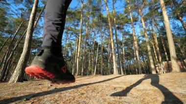 Fitness koşan adam kameranın üzerinden atlar ve maraton antrenmanı için orman yolunda koşmaya devam eder.