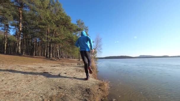 Sportler Blauen Kapuzenpulli Läuft Ufer Entlang Abendlauf Der Natur — Stockvideo