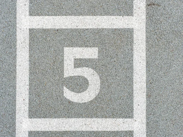 Number five painted on soft rubber surface. Jumping hopscotch game with numbers. Safety outdoor playground. The fifth place