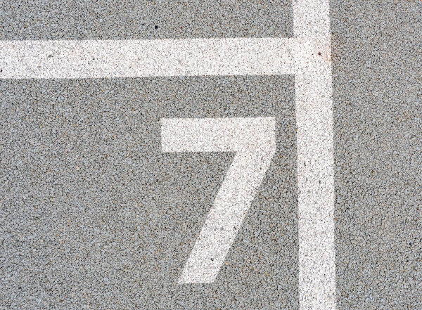 Number seven painted on soft rubber surface. Seventh possition. Jumping hopscotch game with numbers. Safety outdoor playground