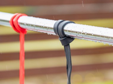 Egzersiz ve lastik elastik bantlar egzersiz korkuluklarında asılı. Yağmurdan sonra insan olmadan egzersiz malzemesi.