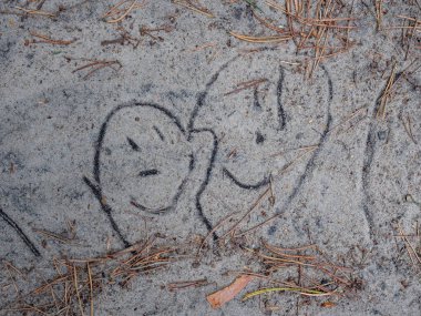 Bir patikadaki kuma çizilmiş iki komik ve gülen yüzün çizimi. Komik gülen yüzler