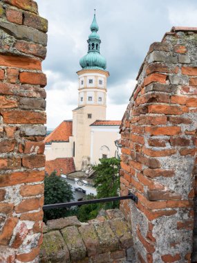 Mikulov kale kulesi. Kayanın tepesindeki inanılmaz romantik şato, şehrin çatılarının manzarası. Güney Moravya Çek Cumhuriyeti