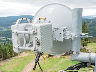 Cep telefonu kulesi gibi antenlerle iletişim kulesine tırman. 9 Eylül 2021, Tanvald, Çek Cumhuriyeti. Uydu çanaklı cep telefonu kulesi, telefon direği