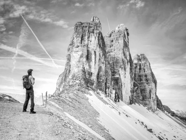 Backpacker on trip aound  Tre Cime di Lavaredo in sunny April  morning. View from tour around popular massive, Dolomite Alps,  Italy. BW, Black and white,