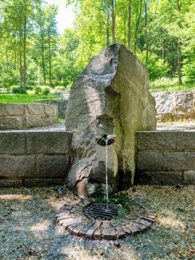 JESENIK SPA - CZECH REPUBLIC - JULY 18, 2022: Slovansky pramen, Slovansky healing spring water and stony mound,  Slovansky Quelle