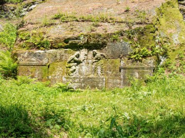 Ostas, Czech republic - Yily 19 2022. Sculptures called Samaritans carved into soft rock in close proximity of healing spring.