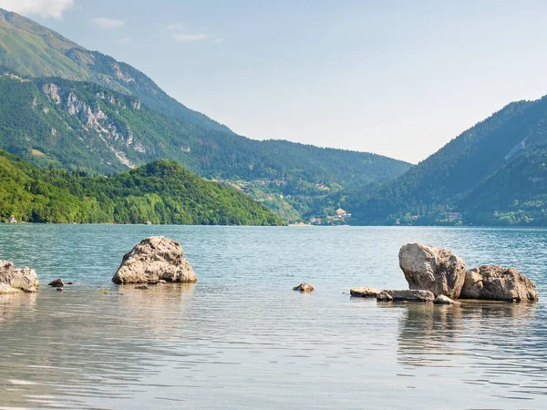 石の山の湖Molvenoの青い緑色の水の海岸にスタック イタリアのブレンタ ドロミテの麓にある村とモルヴェノ湖 — ストック写真