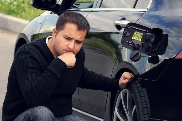 Hombre se sienta y piensa al lado del coche —  Fotos de Stock