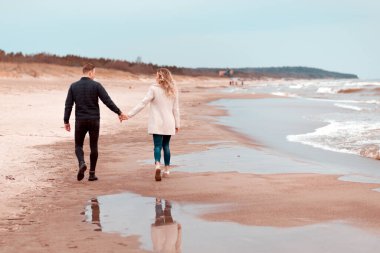 Sevgili çift kumsalda dinleniyor. Aşk konsepti tatili. Geriye bakış. Pring, sonbahar tatili..