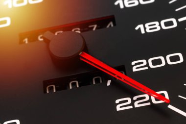 Araba hız göstergesi. Otomobil hız göstergesi 220 km / s gösteriyor. Yakın çekim, koyu siyah arkaplan. Tehlikeli hız kavramı