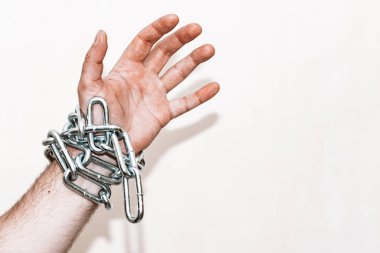 Eli zincirli, elinde zincir, elinde zincir yarası, gri arka plan. Seçmeli odak, kopyalama alanı..