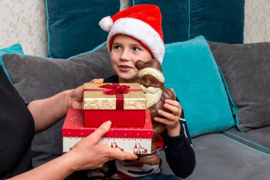 10 'lu yaşlardaki çocuklar ve anneleri evde Noel hediyeleri veriyorlar..