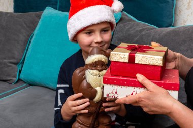 10 'lu yaşlardaki çocuklar ve anneleri evde Noel hediyeleri veriyorlar..