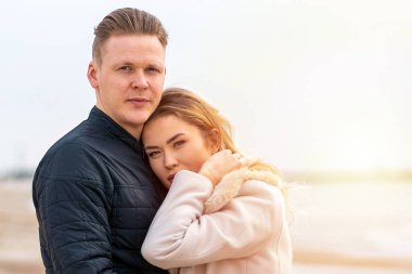 Genç çift sahilde eğleniyor ve eğleniyor. Bahar, sonbahar, sonbahar tatili..