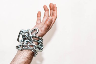 Eli zincirli, elinde zincir, elinde zincir yarası, gri arka plan. Seçmeli odak, kopyalama alanı..