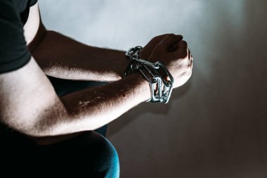 Zincirli zincire vurulmuş beyaz bir adam, hapis konsepti, suçlulara verilen ceza, insan ticareti, erkek ve kadınlara karşı şiddet..