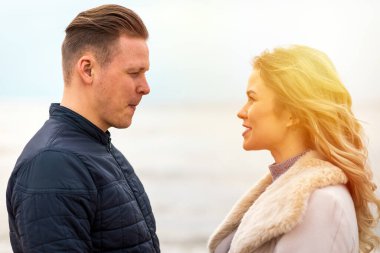 Genç çift sahilde eğleniyor ve eğleniyor. Bahar, sonbahar tatili. Kapanış..