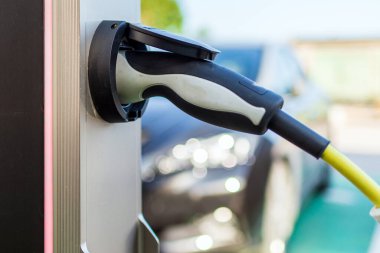 Elektrik kablosu takılı bir elektrikli arabayı şarj etmek. Otomobilin geleceği olan modern elektrikli arabayı şarj etmek.