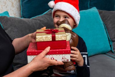 10 'lu yaşlardaki çocuklar ve anneleri evde Noel hediyeleri veriyorlar..