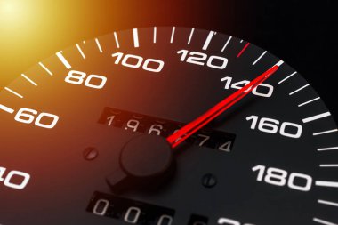 Araba hız göstergesi. Otomobil hız göstergesi 140 km / s gösteriyor. Yakın çekim, koyu siyah arkaplan. Tehlikeli hız kavramı