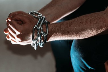 Zincirli zincire vurulmuş beyaz adam, hapis konsepti, suçlulara verilen ceza, insan ticareti, erkek ve kadınlara karşı şiddet..