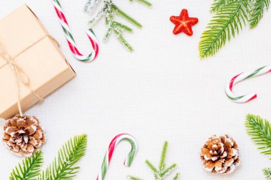 Noel dekorasyonu beyaz arka plan. Noel hediyesi kutusu, çam kozalakları, köknar dalları ve beyaz arka planda yıldız. Düz konum, üst görünüm, kopyalama alanı.