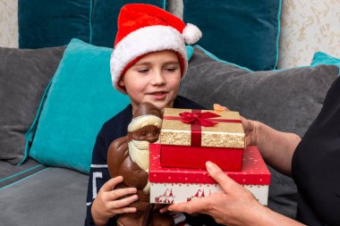 10 'lu yaşlardaki çocuklar ve anneleri evde Noel hediyeleri veriyorlar..