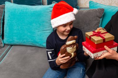 10 'lu yaşlardaki çocuklar ve anneleri evde Noel hediyeleri veriyorlar..