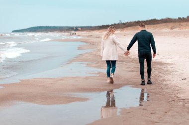 Sevgili çift kumsalda dinleniyor. Aşk konsepti tatili. Geriye bakış. Pring, sonbahar tatili..