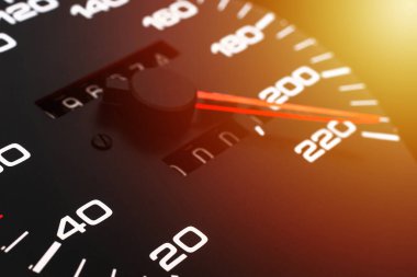 Araba hız göstergesi. Otomobil hız göstergesi 220 km / s gösteriyor. Yakın çekim, koyu siyah arkaplan. Tehlikeli hız kavramı