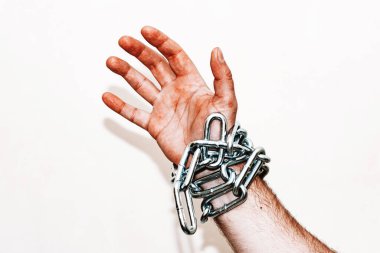 Zincirli el, alttan sarkan zincir, gri arka plan. Boşluğu kopyala, seçici odaklanma..