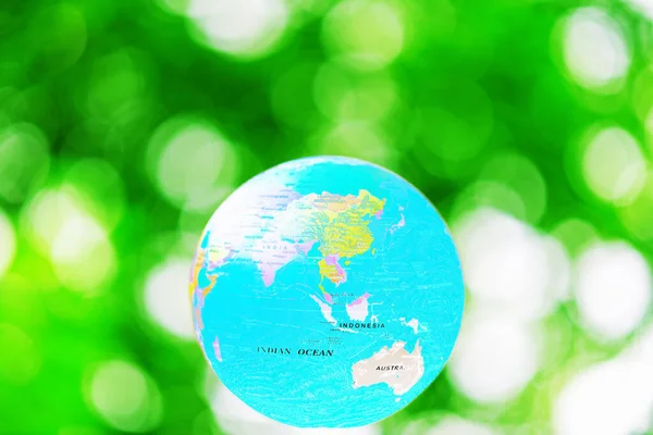Green planet Earth on a green blur background.Environment conservation concept.Copy space.