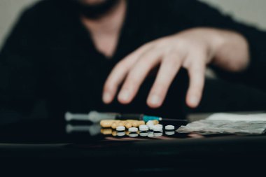 Uyuşturucu bağımlısı elleri, evde, karanlık oturma odasında aşırı dozda eroin ya da arzuyla uzanır..