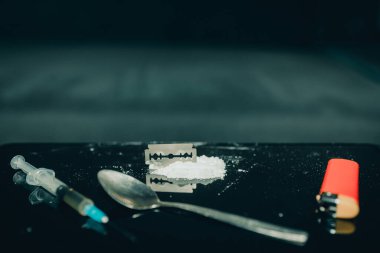 Farklı uyuşturucular, şırınga, kaşık, çakmak, jilet konsepti uyuşturucu bağımlılığını durdurur. Masada beyaz toz ve uyuşturucu uyuşturucusu ve şırınga bulunur. Yasadışı iş, cezai sorumluluk ile suçlanıyor. Anlaşıldı..