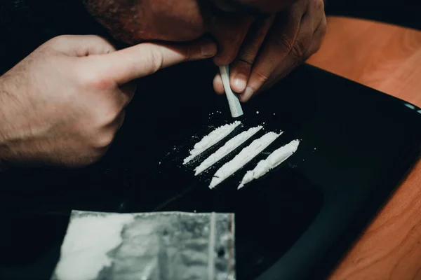 麻薬中毒者 薬物乱用 薬を飲んでいる男 コカインの白色の粉末の線を曲げて 閉じて トーン — ストック写真
