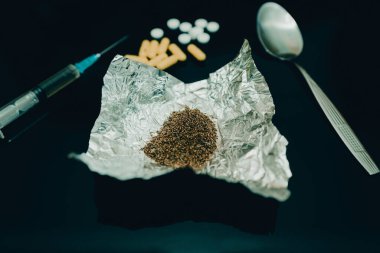 Farklı ilaçlar, şırınga. Konsept uyuşturucu bağımlılığını durdurur. Masada beyaz toz ve uyuşturucu hapları kaşık dolusu uyuşturucu ve şırınga var. Yasadışı iş, cezai sorumluluk ile suçlanıyor..