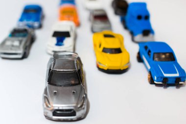 Yoldaki minyatür araba oyuncakları grubu. Beyaz arka planda birden fazla oyuncak araba içeren trafik sıkışıklığı kavramı. Kirlilik. Küresel ısınma, CO2 kavramı.
