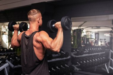 Spor salonunda aptal gibi egzersiz yapan genç ve formda bir adam. Sağlıklı bir adam aptallarla çalışıyor. Kapalı alanda çekim yapıyor..