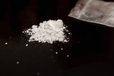 Plastik torbada kokain tozu ve siyah arka planda kokain tozu. Boşluğu kopyala.
