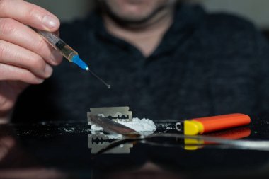 Şırınga eroin alıyor. Bağımlı karanlık oda. Uyuşturucu bağımlısı bir sonraki doz için hazırlanıyor..