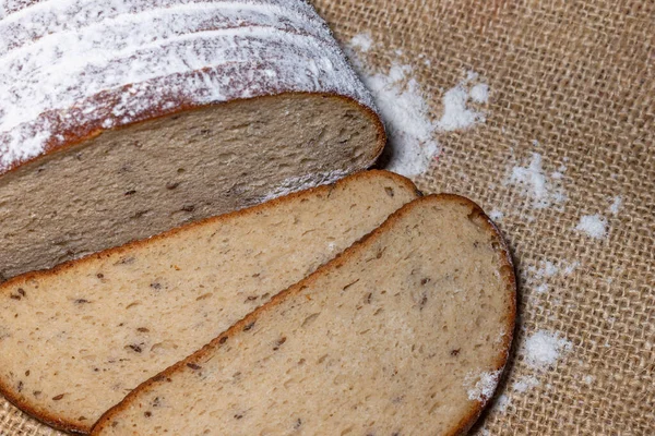 小麦粉パンの切り身と2枚のスライスがリネンベージュのキャンバスにカットされています — ストック写真