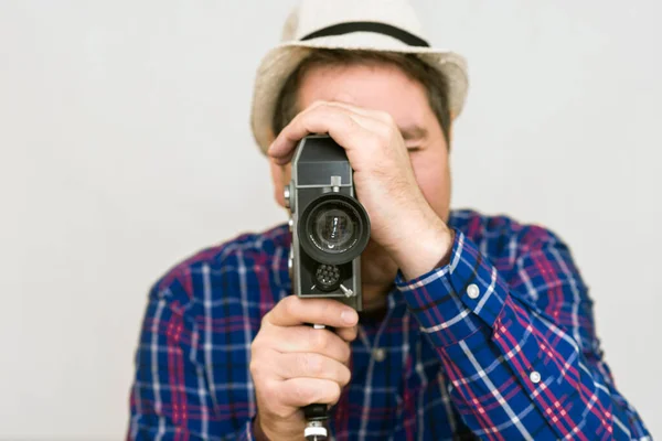 カメラを持つ男 カメラマンは レトロなカメラで映画を作る スーパーで撮影した再生シャツを持つ男8カメラ室内 — ストック写真