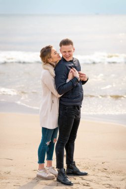 Genç çift sahilde eğleniyor ve eğleniyorlar. İlkbahar, sonbahar tatili..